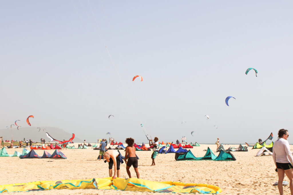 colorful image of kite surfers setting up their kite and gear at kite beach of the island Sal in Cabo Verde