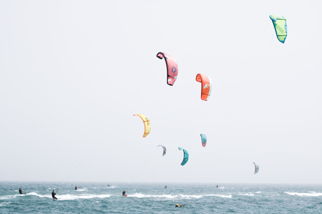 Various Kites in the air over the turqouise waters of Cabo Verde at Kite Beach on the island of Sal